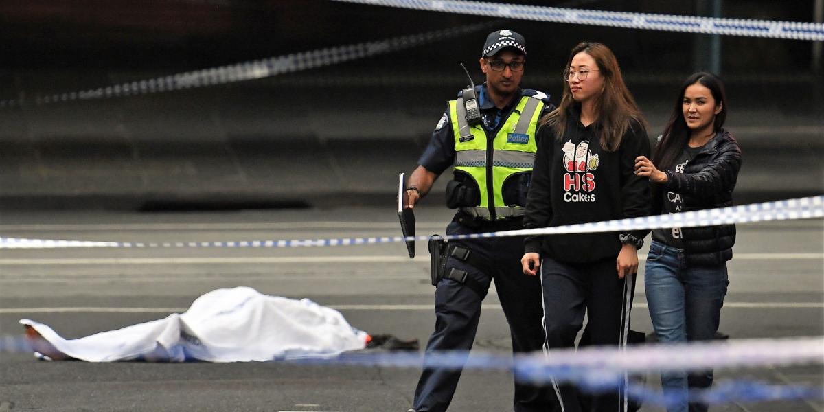 Járókelőt kísérnek ki a rendőrök a melbourne-i vérontás helyszínéről