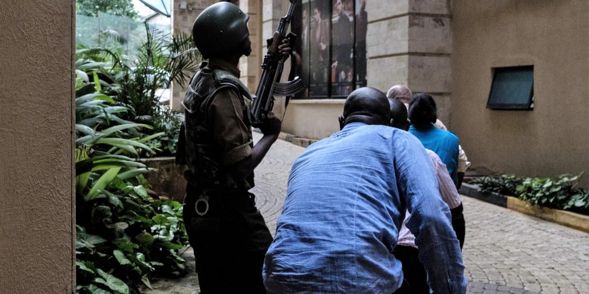 Civilek menekülnek katonai fedezet mellett a nairobi DusitD2 hotel közeléből, ahol 2019. január 15-én terrortámadást hajtott vég