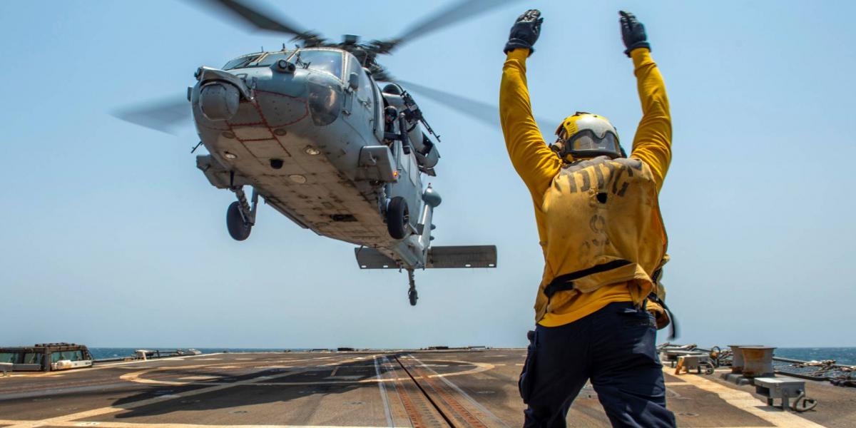 Seahawk amerikai harci helikoptert irányít egy tengerész az USS Bainbridge  rombolóhajó fedélzetén. Képünk illusztráció