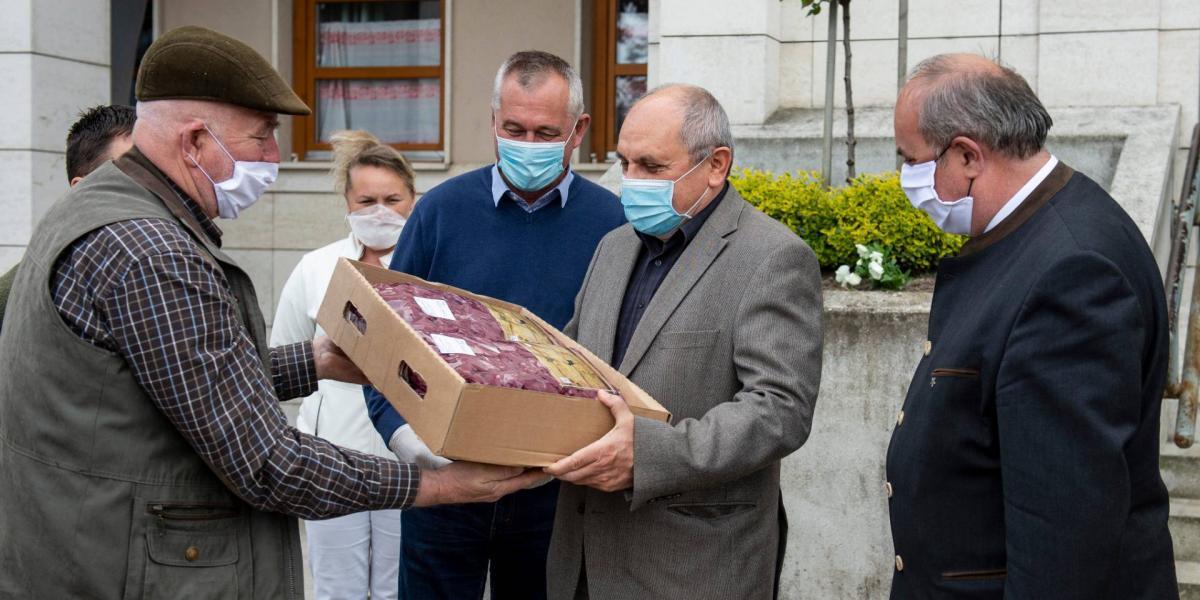 Zambó Péter, az Agrárminisztérium erdőkért és földügyekért felelős államtitkára (j) a helyi vadgazdálkodók által az egészségügyi dolgozók részére felajánlott vadhús átadásán a balassagyarmati Dr. Kenessey Albert Kórház-Rendelőintézet előtt