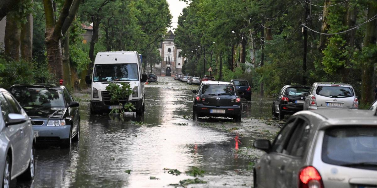 Autók a felhőszakadás után esővízzel elárasztott úton Budapesten, az Illatos úton