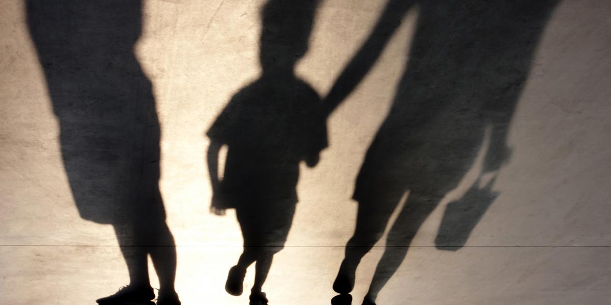 Blurry,Shadows,Of,Mother,Walking,With,Son,Hand,In,Hand