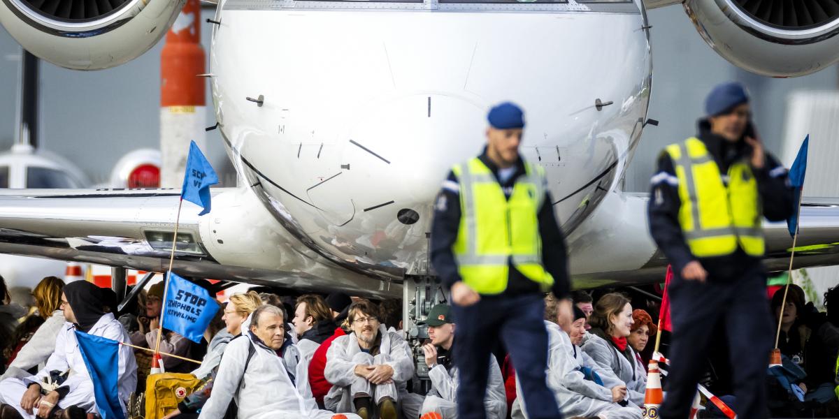 Fehér overált viselő aktivisták százai megrohamoztak egy magánrepülőgépeknek fenntartott területet az amszterdami Schiphol repülőtéren