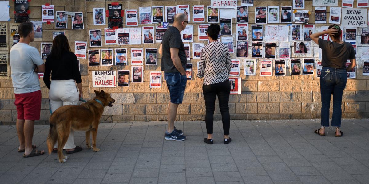 Izraeliek Tel-Avivban, a túszul ejtett személyek fényképei előtt