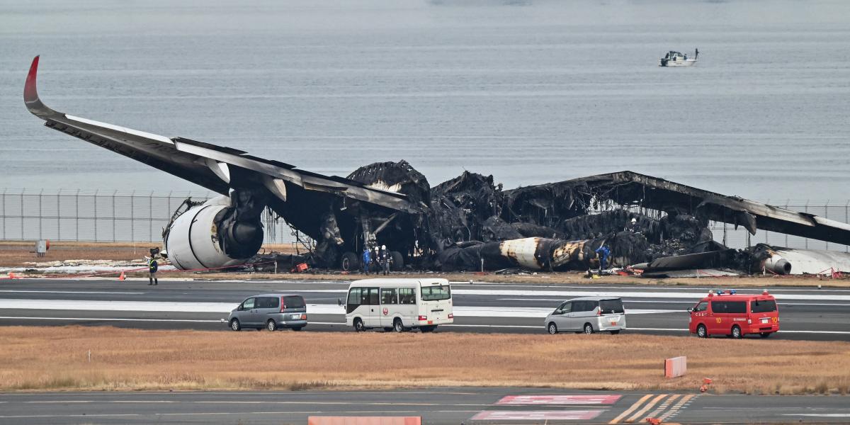 A Japan Airlines utasszállítójának kiégett roncsai a tokiói Haneda nemzetközi repülőtéren 2024. január 3-án