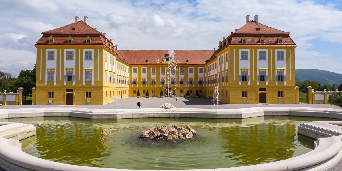 A Schloss Hof kastély barokk épülete, az előtérben a park Neptun-kútja