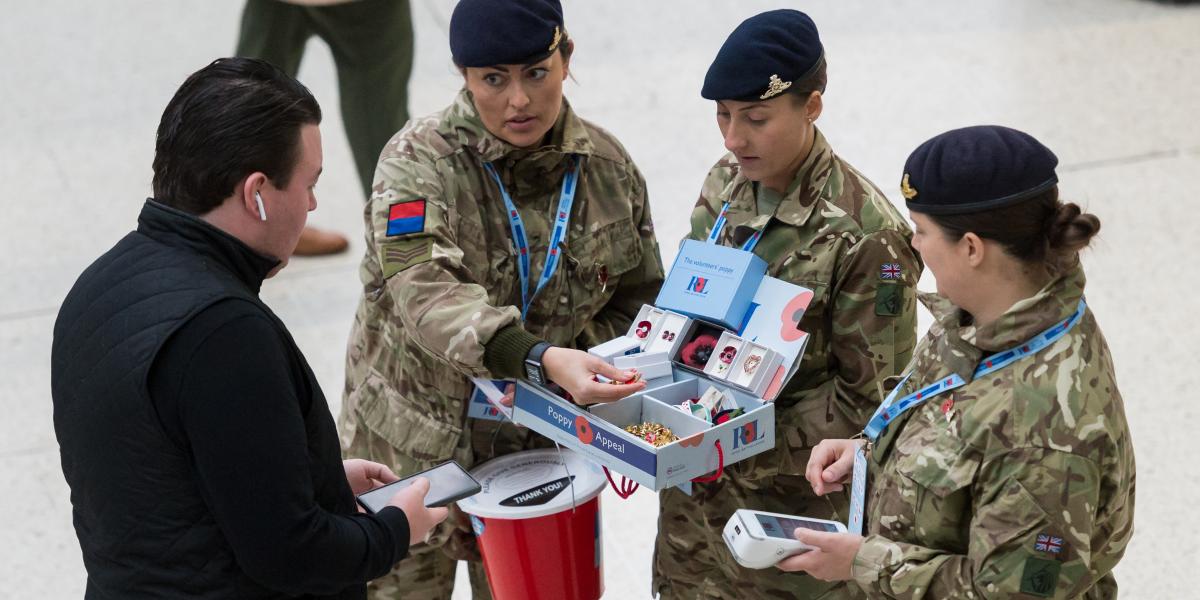 Remembrance Day Londonban. A hősi halottakra való emlékezés napján önkéntesek selyemből készült kitűzhető pipacsokat kínálgatnak 