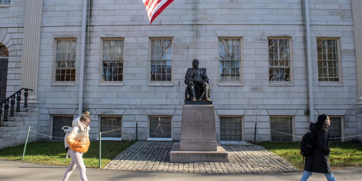 John Harvard puritán lelkipásztor szobra a világhírű egyetem campusán. Nehéz csatának néz elébe