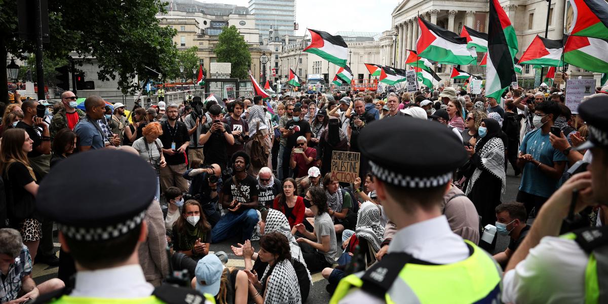 London belvárosában, a Trafalgar téren, a Nemzeti Galéria előtt tüntetők palesztin zászlókat lengetve vettek részt egy demonstráción, amelyet a palesztinbarát Palestine Action csoport támogatására szerveztek 2025. június 23-án