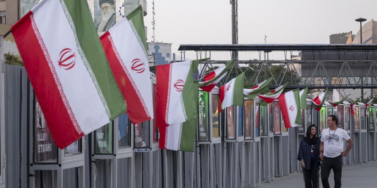 Egy iráni pár sétál az izraeli támadásokban elesett iráni civilek és az IRGC parancsnokainak emlékművei mellett Teherán belvárosában, 2025. június 23-án