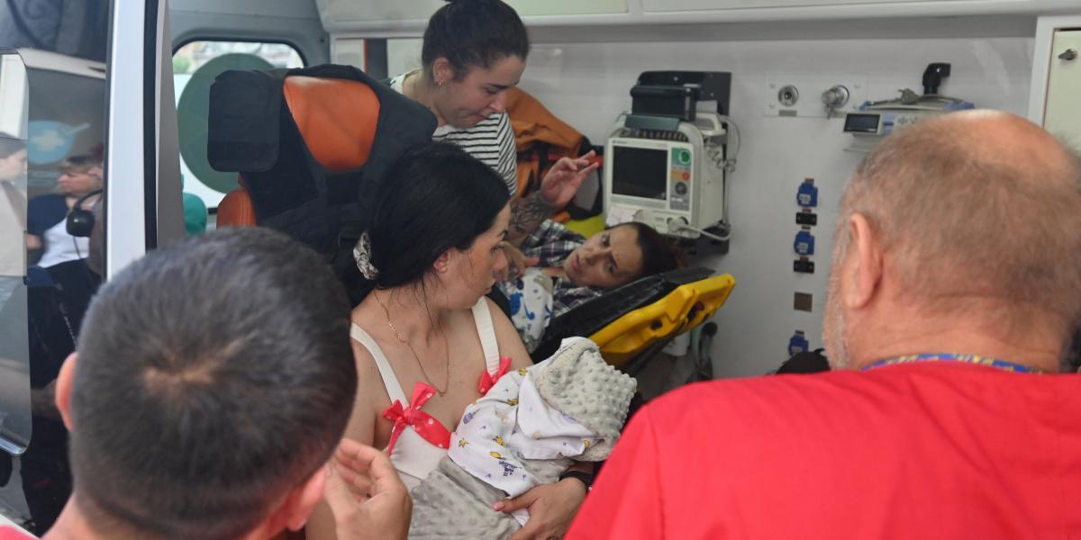 Az egészségügyi személyzet anyákat és újszülöttjeiket evakuál egy szülészeti kórházból, amely megsérült egy dróntámadás után Harkiv központjában, 2025. július 11-én