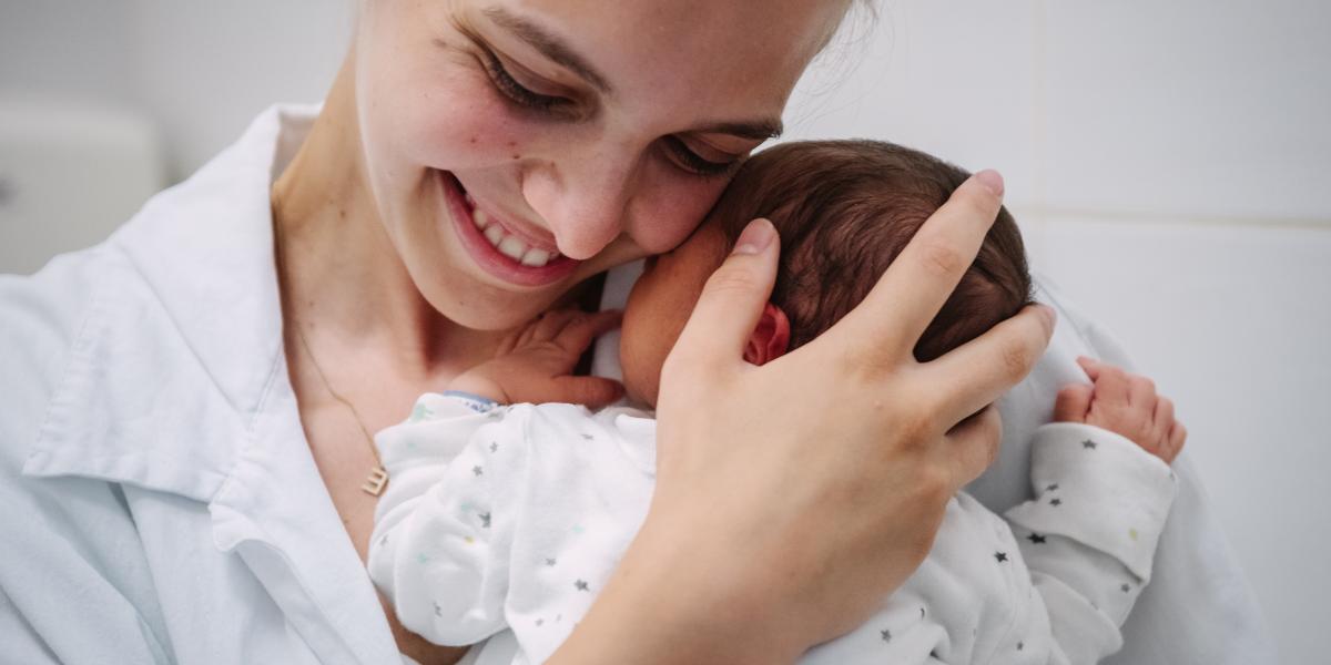 Egyetemista önkéntesek kórházban maradt újszülötteket gondoznak, ringatnak. Fotónkon Kőhalmi Eszter egy kisbabával.