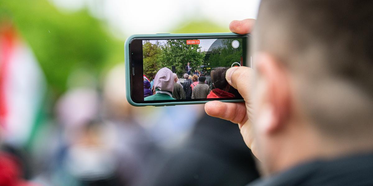 Illusztráció: Magyar Péter beszédét videózó férfi Szarvason 2024. április 18-án 