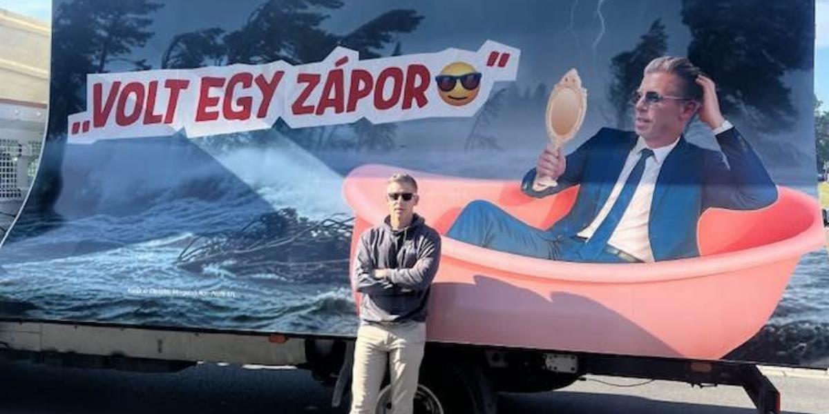 Magyar Péter a fideszes Nemzeti Ellenállási Mozgalom egyik őt lejárat plakátja előtt