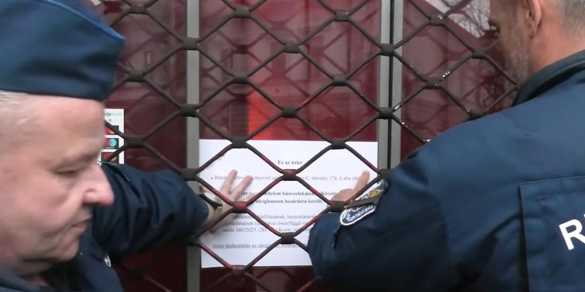 Rendőrök helyezik ki a bezárás okáról szóló tájékoztatót.