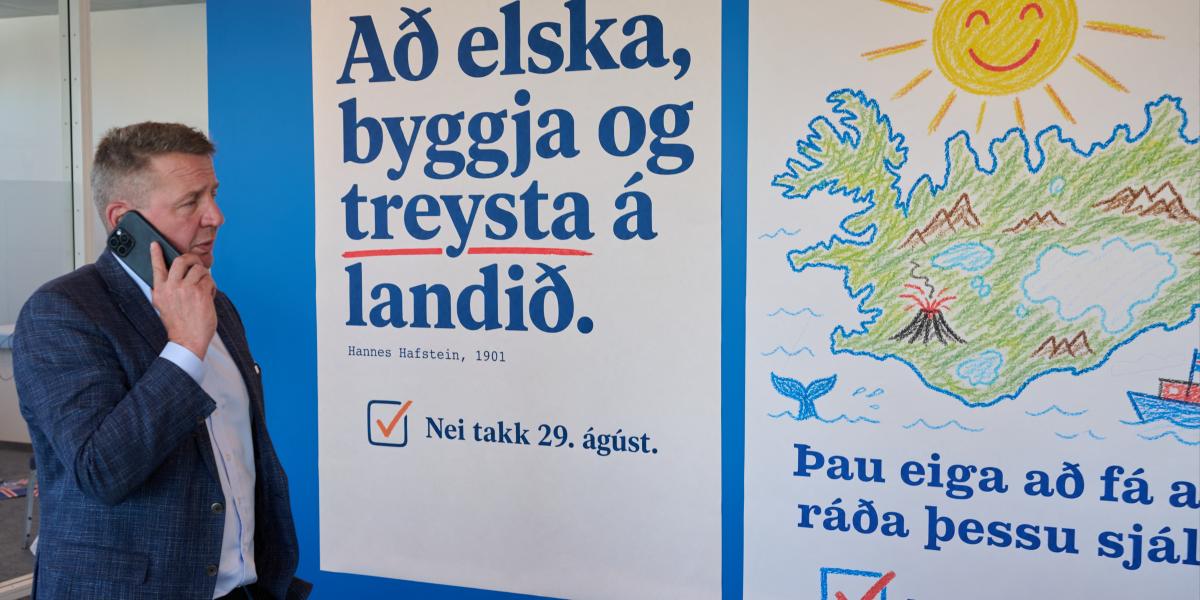 Gudlaugur Thor Thordarson volt izlandi külügyminiszter 2026. augusztus 28-án Reykjavikban egy nemmel szavazásra buzdító plakát mellett 