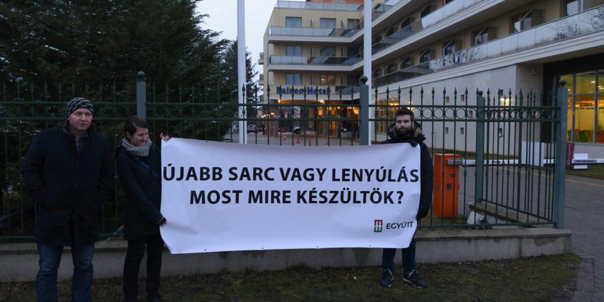 Pápa Levente, az Együtt elnökségi tagja és pártja aktivistái egy "Újabb sarc vagy lenyúlás/Most mire készültök? feliratú transzp