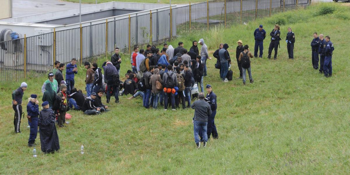 Rendőrök őriznek határsértőket, akiket a Tisza árterében, Szeged közelében fogtak el 2015. június 24-én. MTI Fotó: Kelemen Zoltá