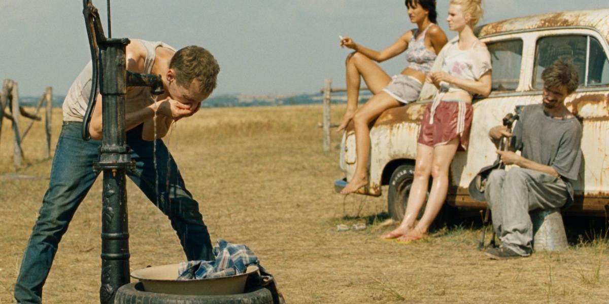 Trokán Nóra és Kurta Niké a roncsautón, Tzafetás Roland mellettük figyeli a főszereplő Jankovics Pétert a kútnál Forrás: Vertigo