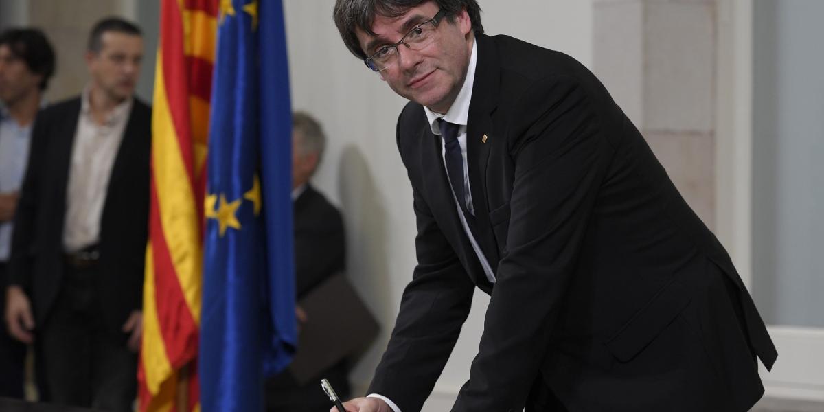 A katalán regionális kormány elnöke, Carles Puigdemont  aláírja a függetlenségről szóló dokumentumot. FOTÓ: LLUIS GENE / AFP