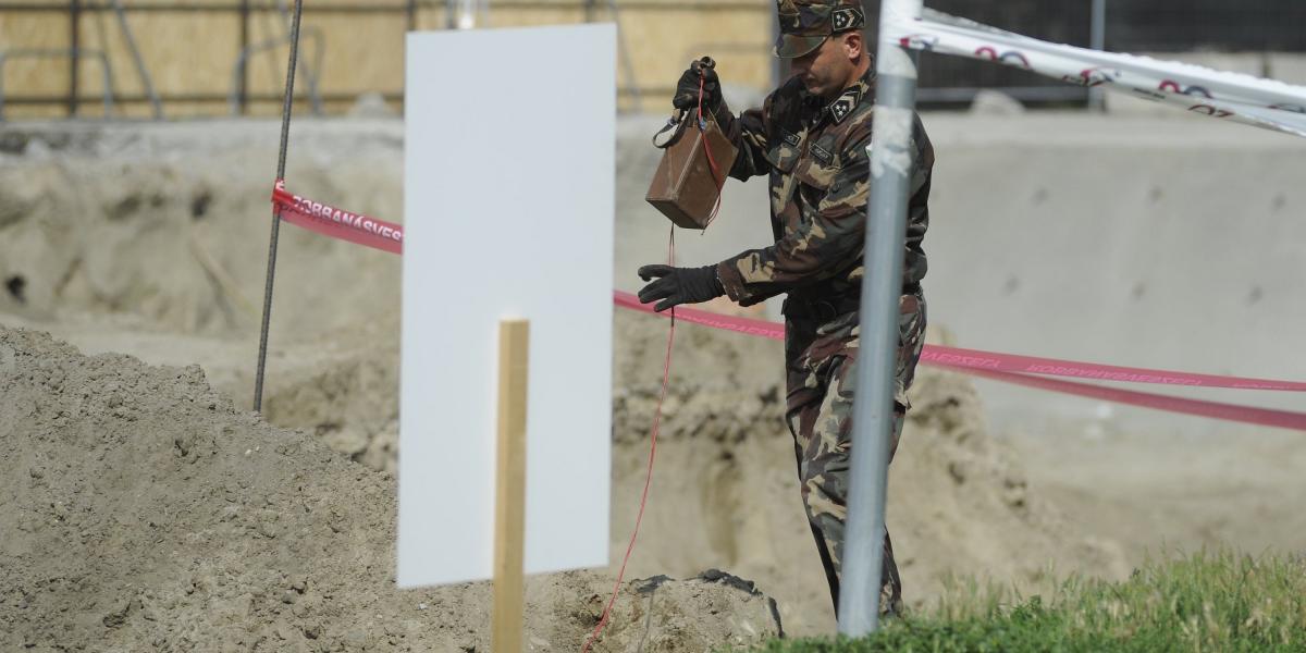 Egy tűzszerész az elszállítás előtti előkészületi munkát végzi az építkezés közben előkerült 120 milliméter átmérőjű, kilőtt, sz