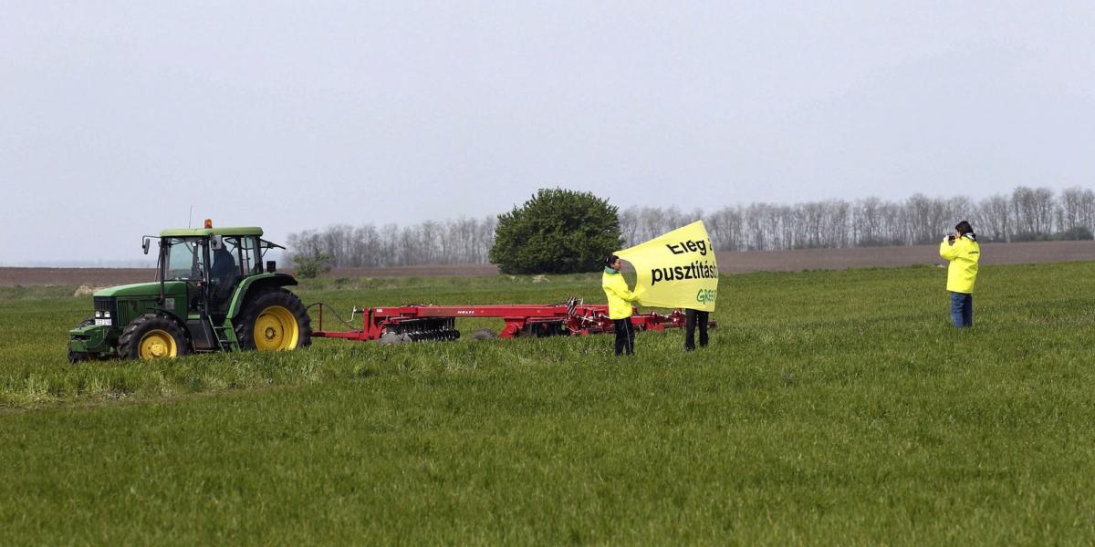 A Greenpeace aktivistái "ELÉG A PUSZTÍTÁSBÓL!" feliratú transzparenssel egy munkagép előtt a Fejér megyei Kishantoson 2014. ápri