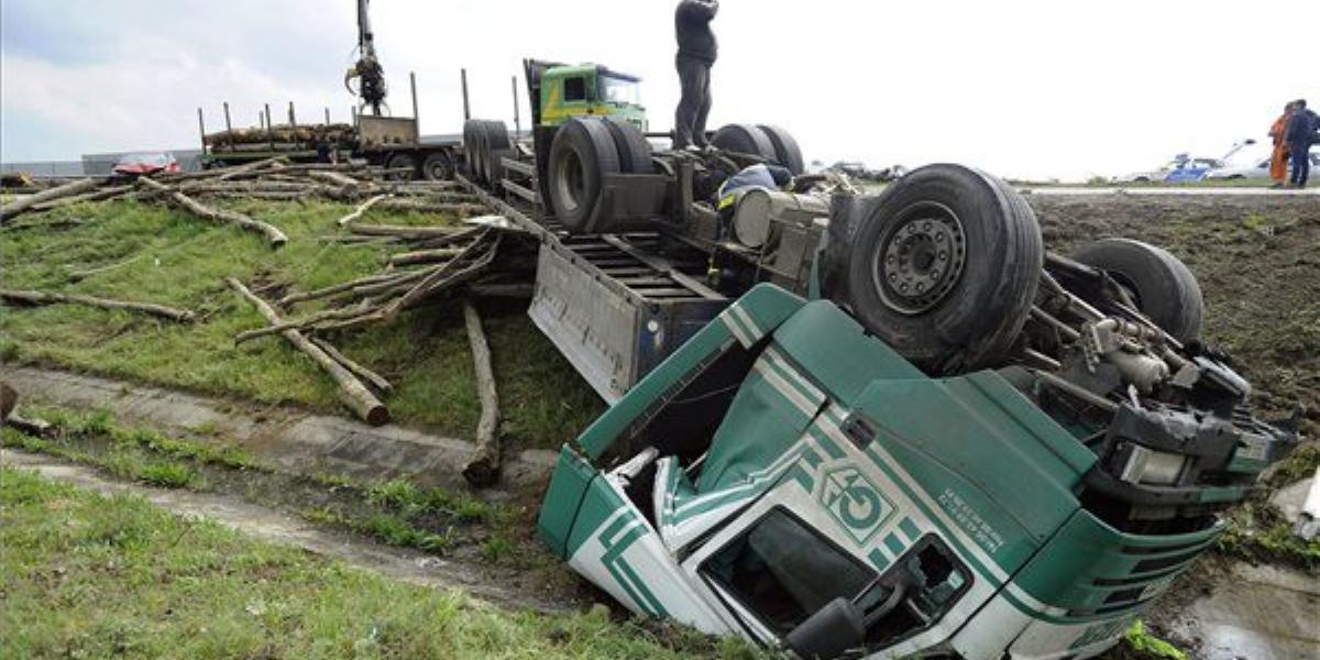 Tűzoltók dolgoznak egy tetejére borult kamion műszaki mentésén a 4-es főúton, Üllő közelében 2014. április 26-án. A rönkfát szál