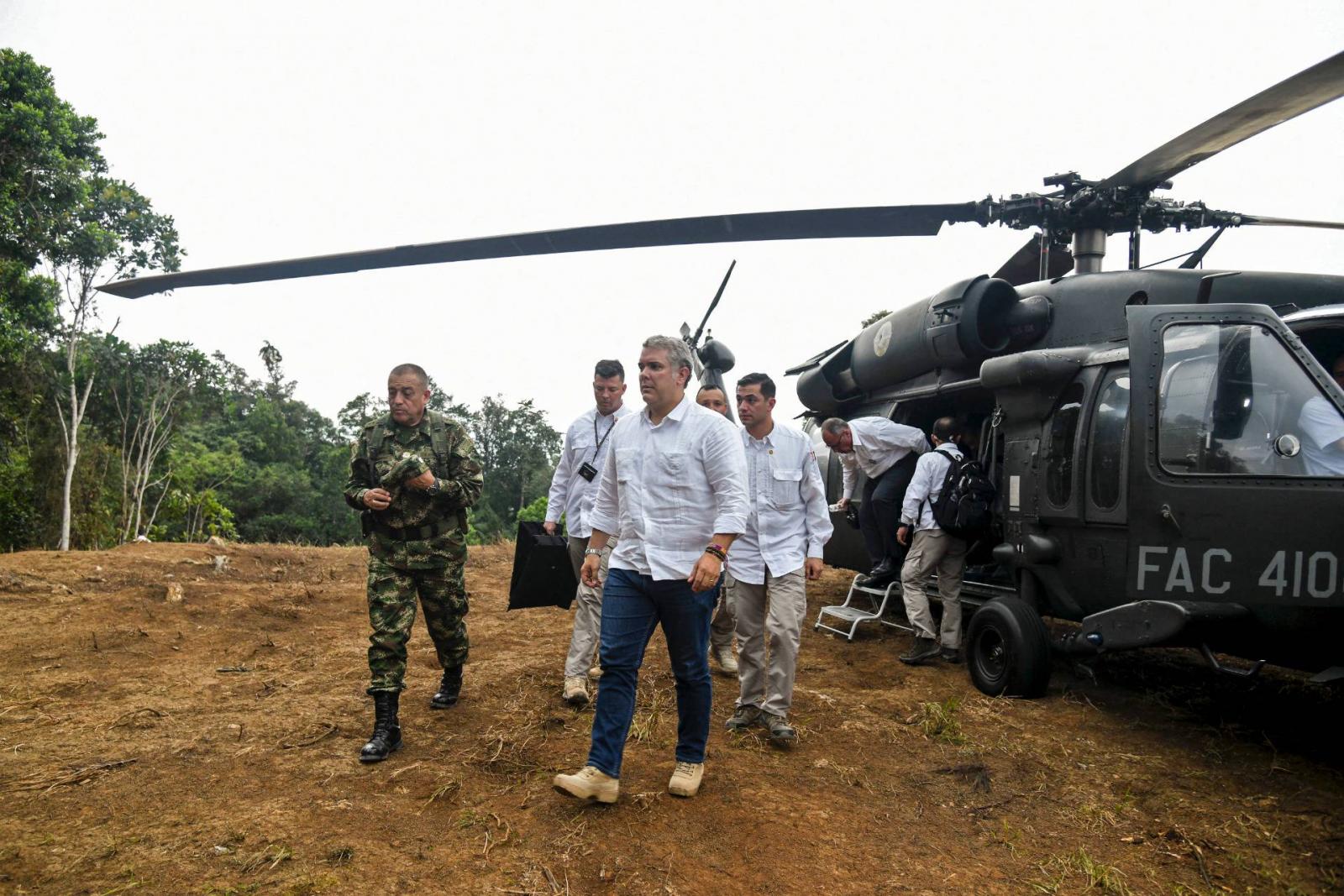 Duque és kíésrete kiszáll a helikopterből.