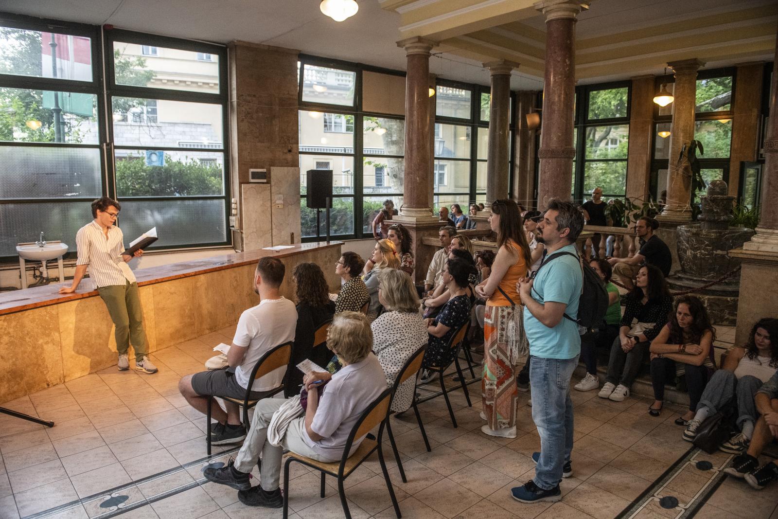 A magyar irodalmat Regős Mátyás Valami édeset című novellája képviselte, felolvas: Kenéz Ágoston a Szent Lukács Gyógyfürdő ivócsarnokában