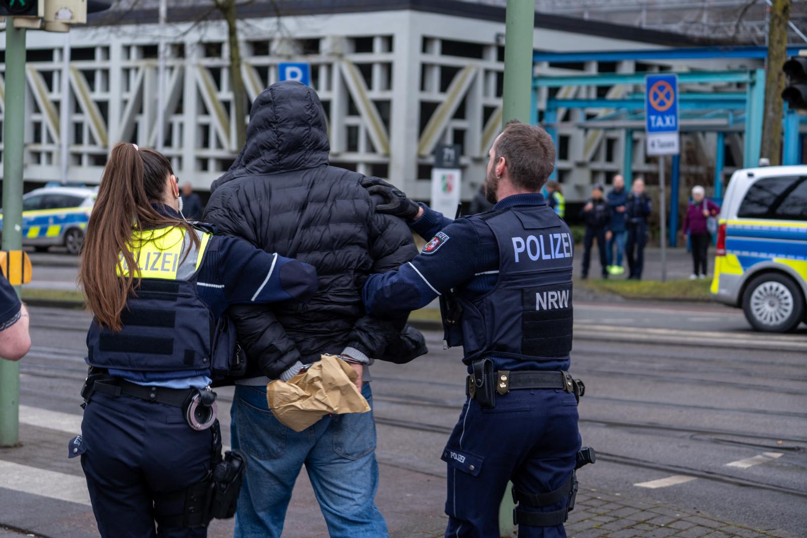 Rendőrök vezetnek el egy férfit, miután lövöldözés volt egy bíróság épületénél az északnyugat-németországi Bielefeld városában