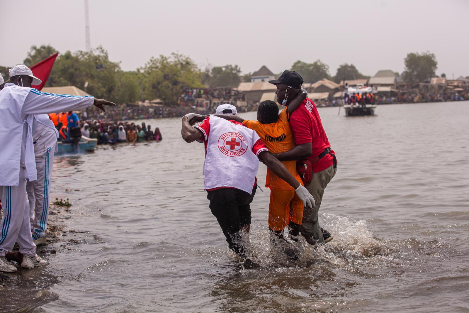 A Vöröskereszt munkatársai támogatnak egy gyászolót, aki elvesztette lányát és testvérét egy szemétlerakó-omlásban, Kampalában 2024. augusztus 10-én. Nyolcan vesztették életüket, köztük két gyermek