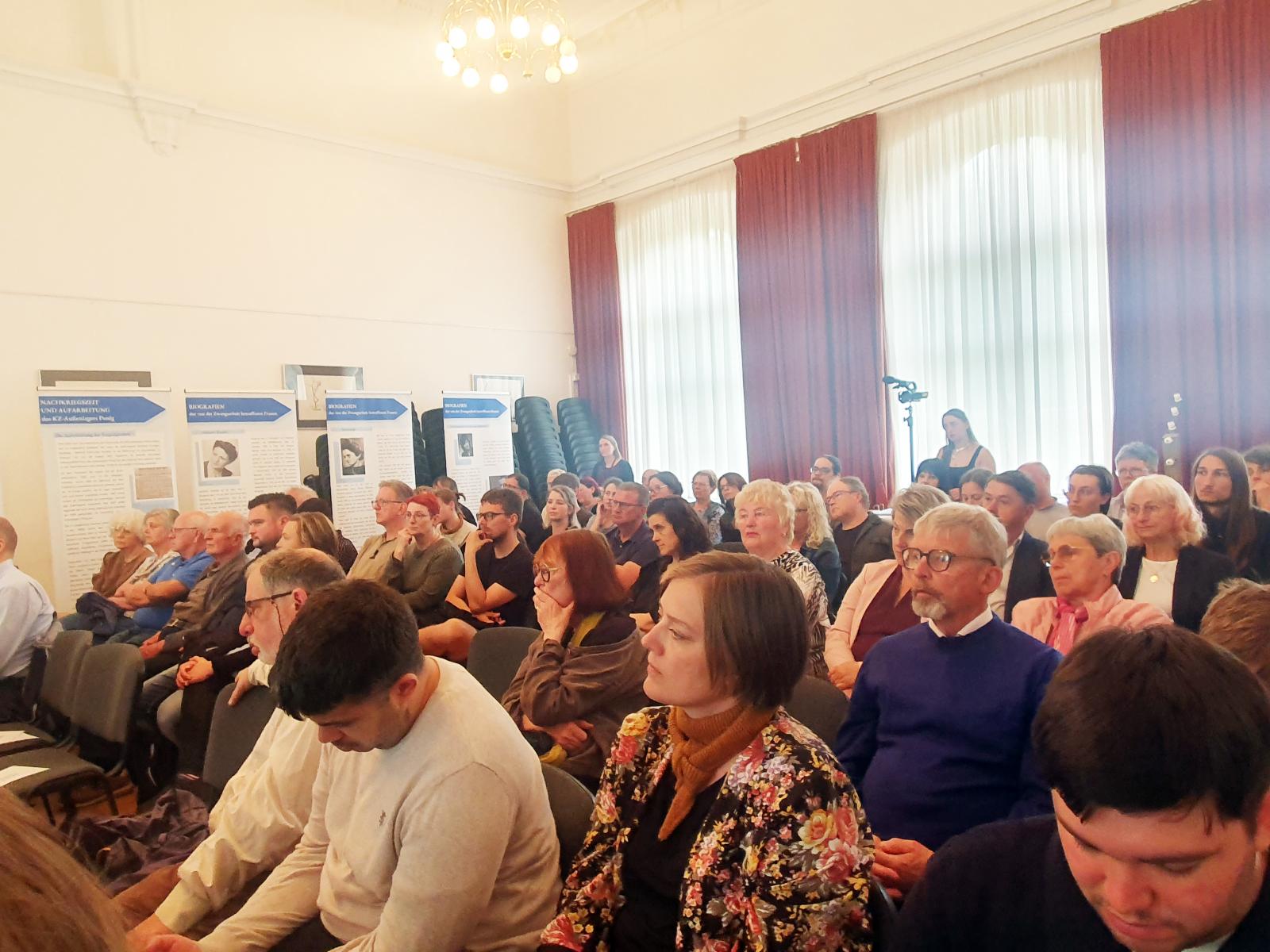 A civil kezdeményezésre
létrejött
megemlékezés
résztvevői,
köztük a túlélők
utódai – háttérben
a kiállítás