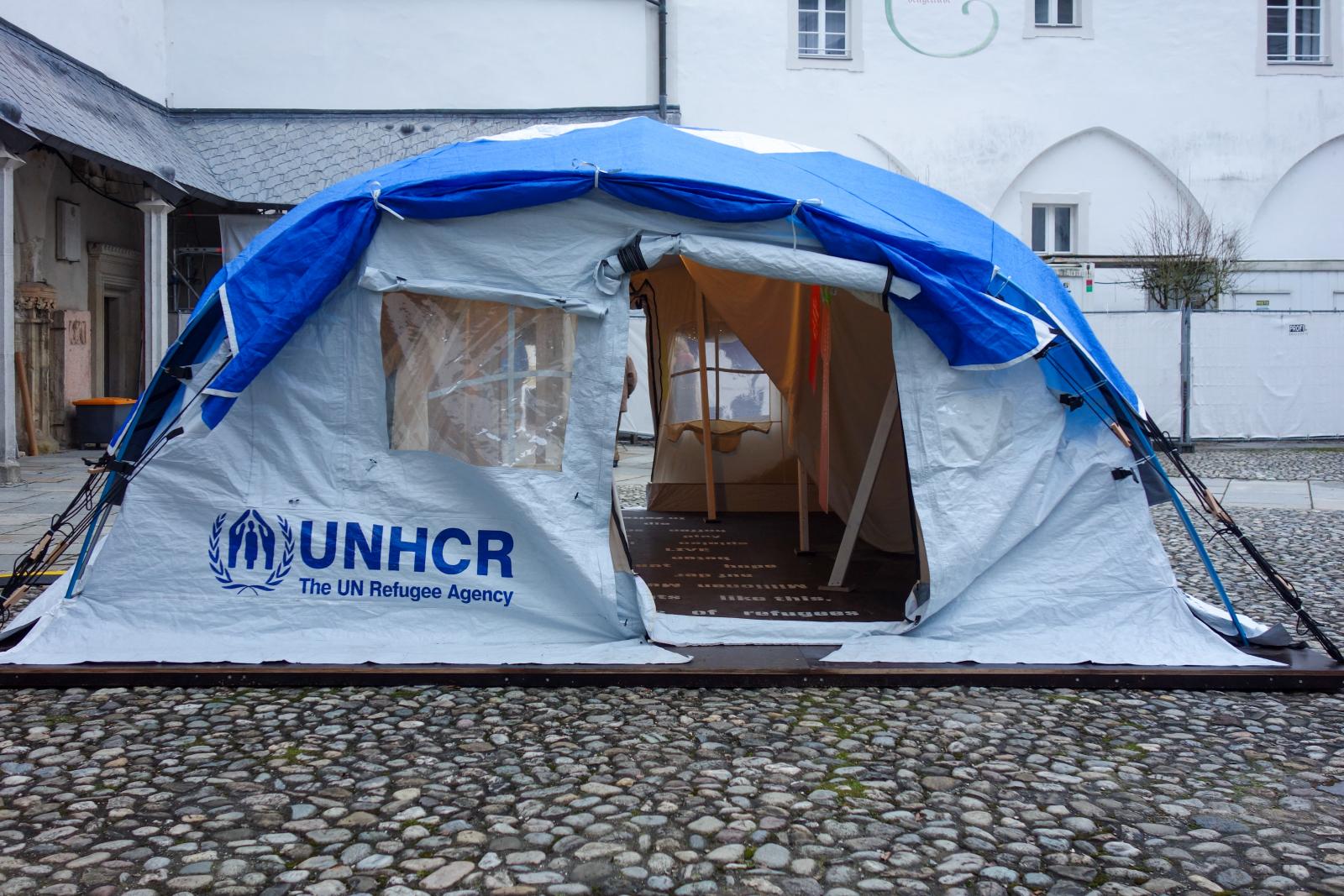 ENSZ-menekültsátor a passaui dóm belső udvarán, amelyet pedagógiai célból állítottak fel, az emberekben meglévő alantas ösztönök ellensúlyozásaként