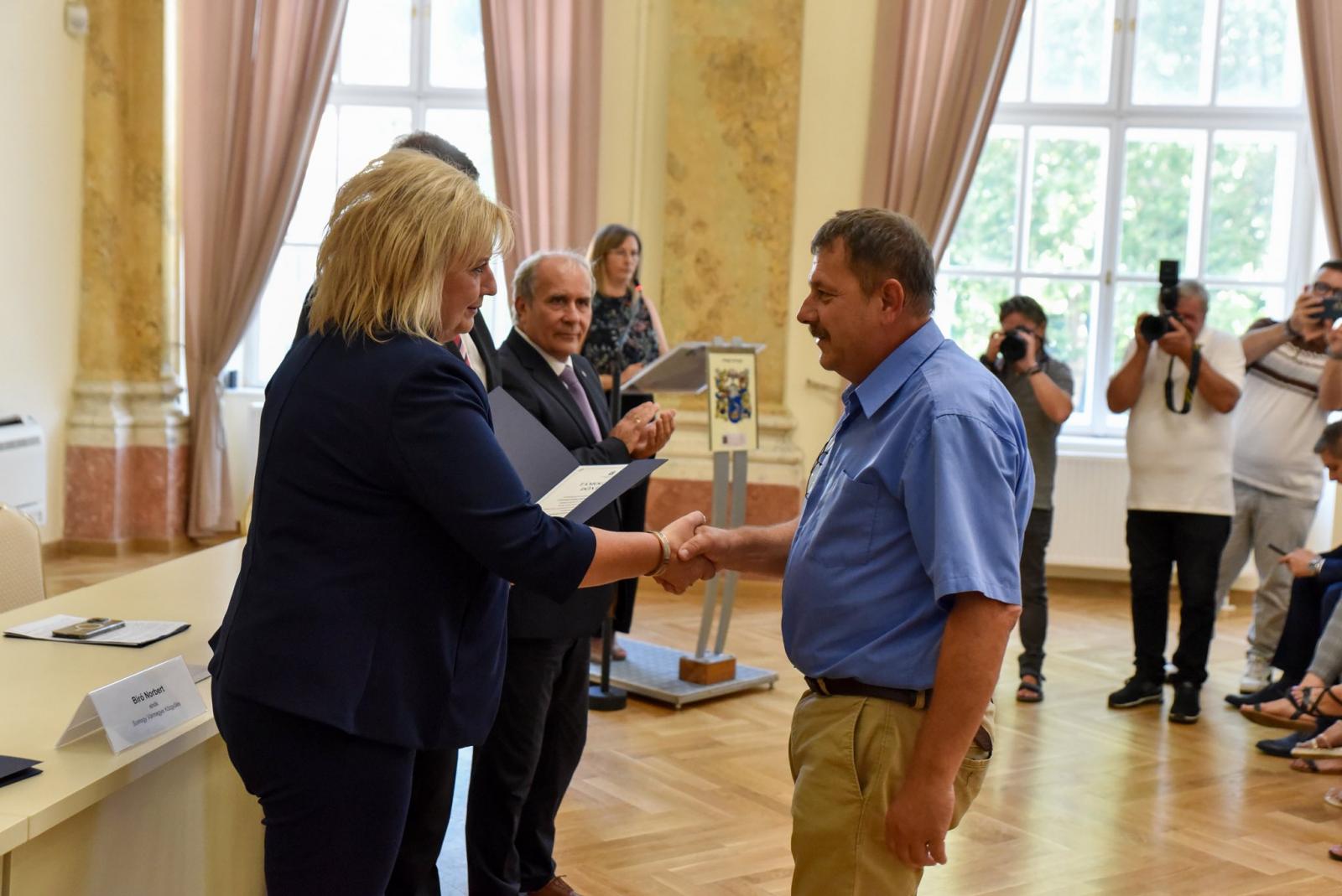 Vág, mutat, beszél, gratutál, etc., és bár mindenkit kellene képviselnie, mégis pártpolitizál minden szégyenérzet nélkül