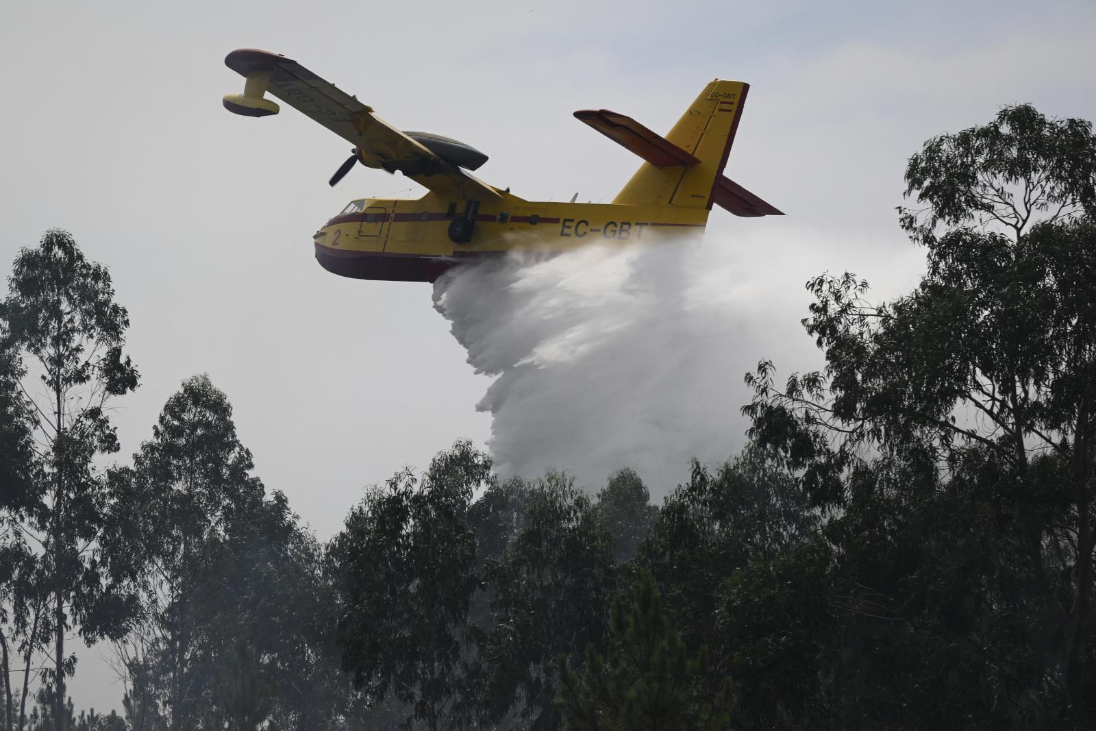 Egy Canadair típusú spanyol tűzoltó repülőgép vizet enged le egy erdőtűzre a közép-portugáliai Daires falu közelében 2026. július 5-én