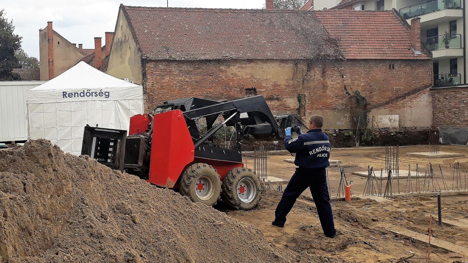 Helyszínelő rendőr fotóz a debreceni építkezés területén