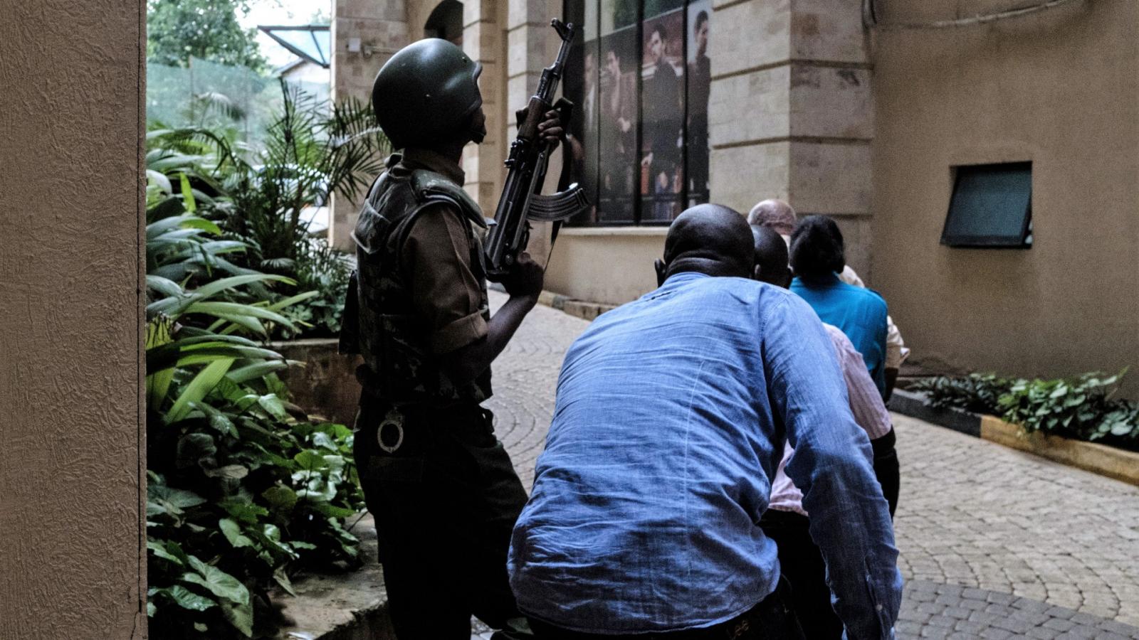 Civilek menekülnek katonai fedezet mellett a nairobi DusitD2 hotel közeléből, ahol 2019. január 15-én terrortámadást hajtott vég