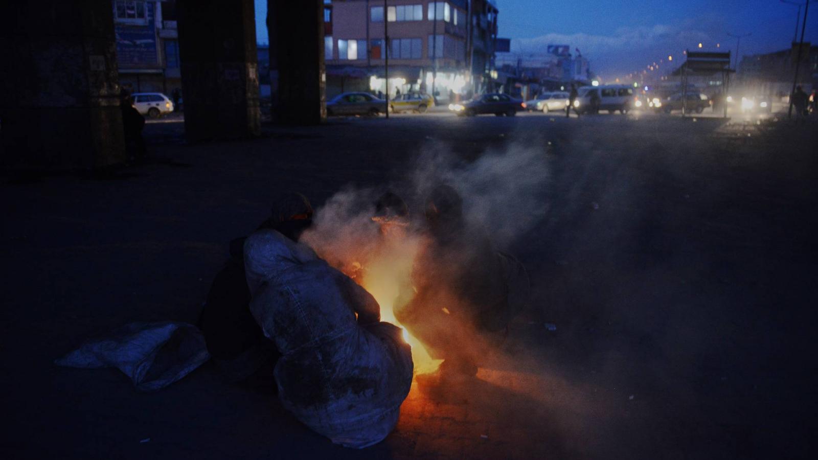 Hajléktalanok melegednek egy tűznél Kabulban - illusztráció