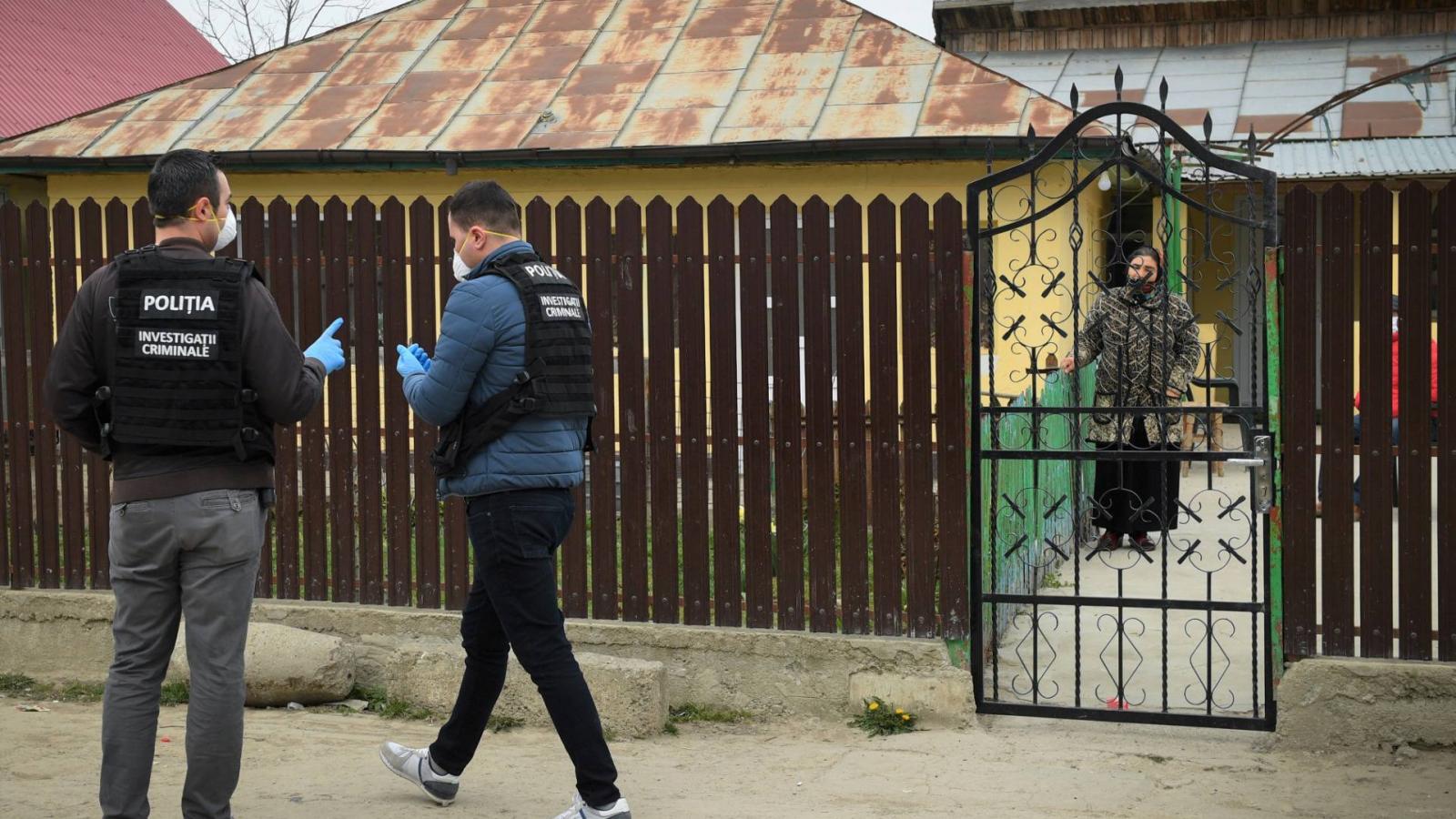 Román rendőrök kérnek a házban maradásra egy roma nőt Tandarei városban, 2020. április 4-én, ahol a nagyarányú fertőzöttség miatt a hatóságok, teljes kijárási tilalmat rendeltek el. Képünk illusztráció