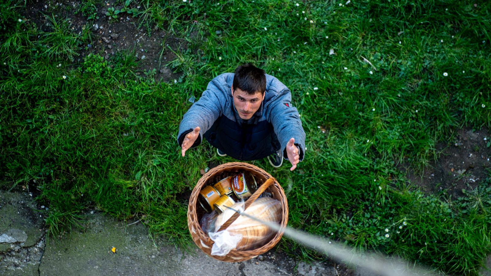 A hajléktalanok csak felcsöngetnek, és az erkélyről kosárban engedi le nekik a pakkot