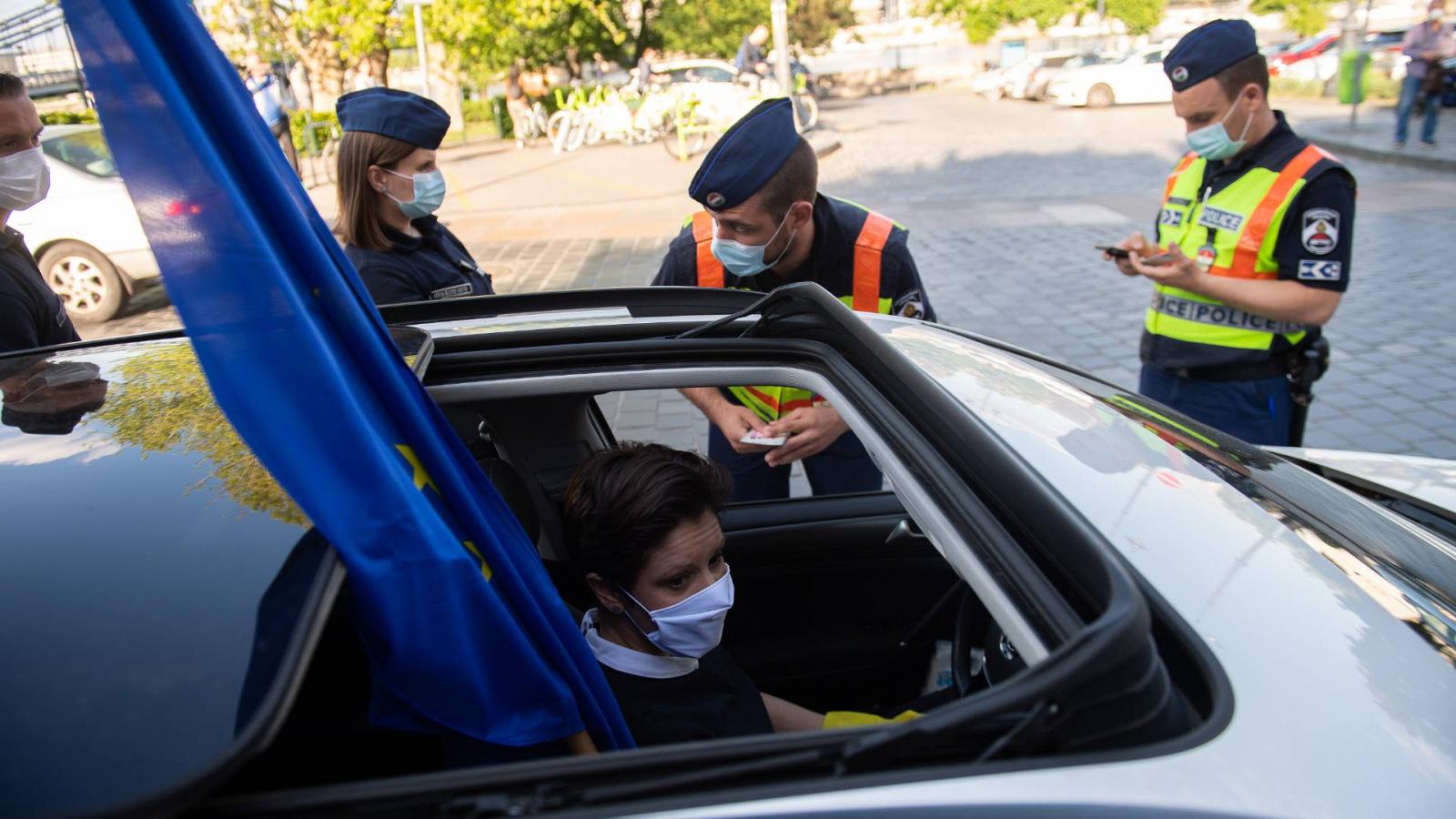 Szél Bernadettet rendőrök igazoltatják egy május 4-i dudálós demonstráción a fővárosi  Clark Ádám téren