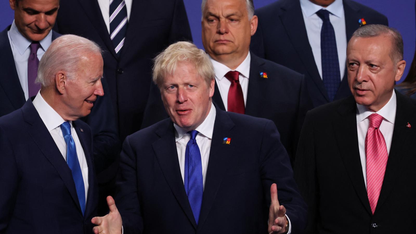 Joe Biden és Boros Johnson volt brit miniszterelnök beszélgetése a 2022. június 29-i NATO-csúcson Orbán Viktor és Recep Tayyip Erdogan török elnök vigyázó szemei előtt.