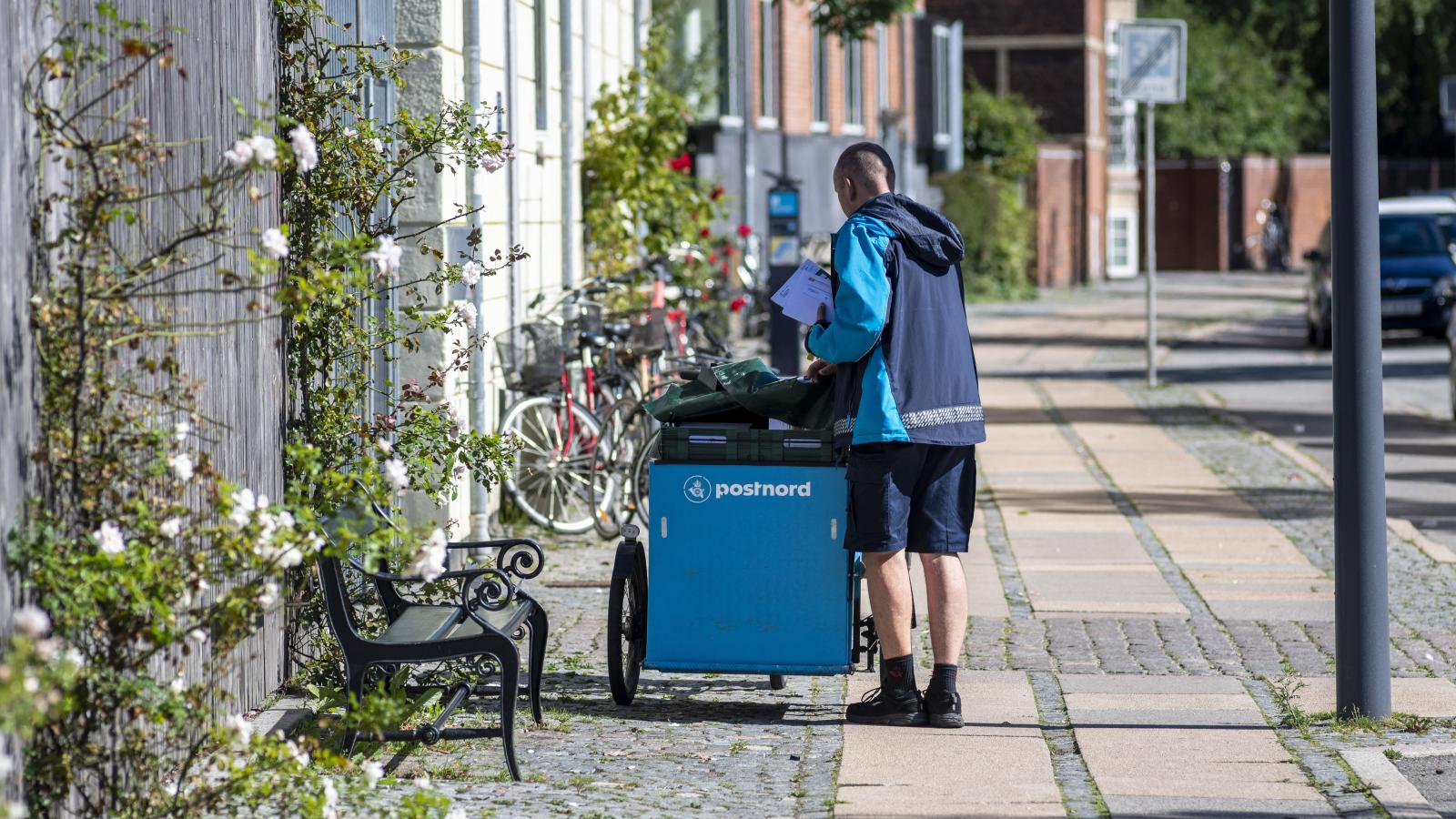 A dán állami Postnord postása leveleket kézbesít Koppenhágában 2020. augusztus 31-én.