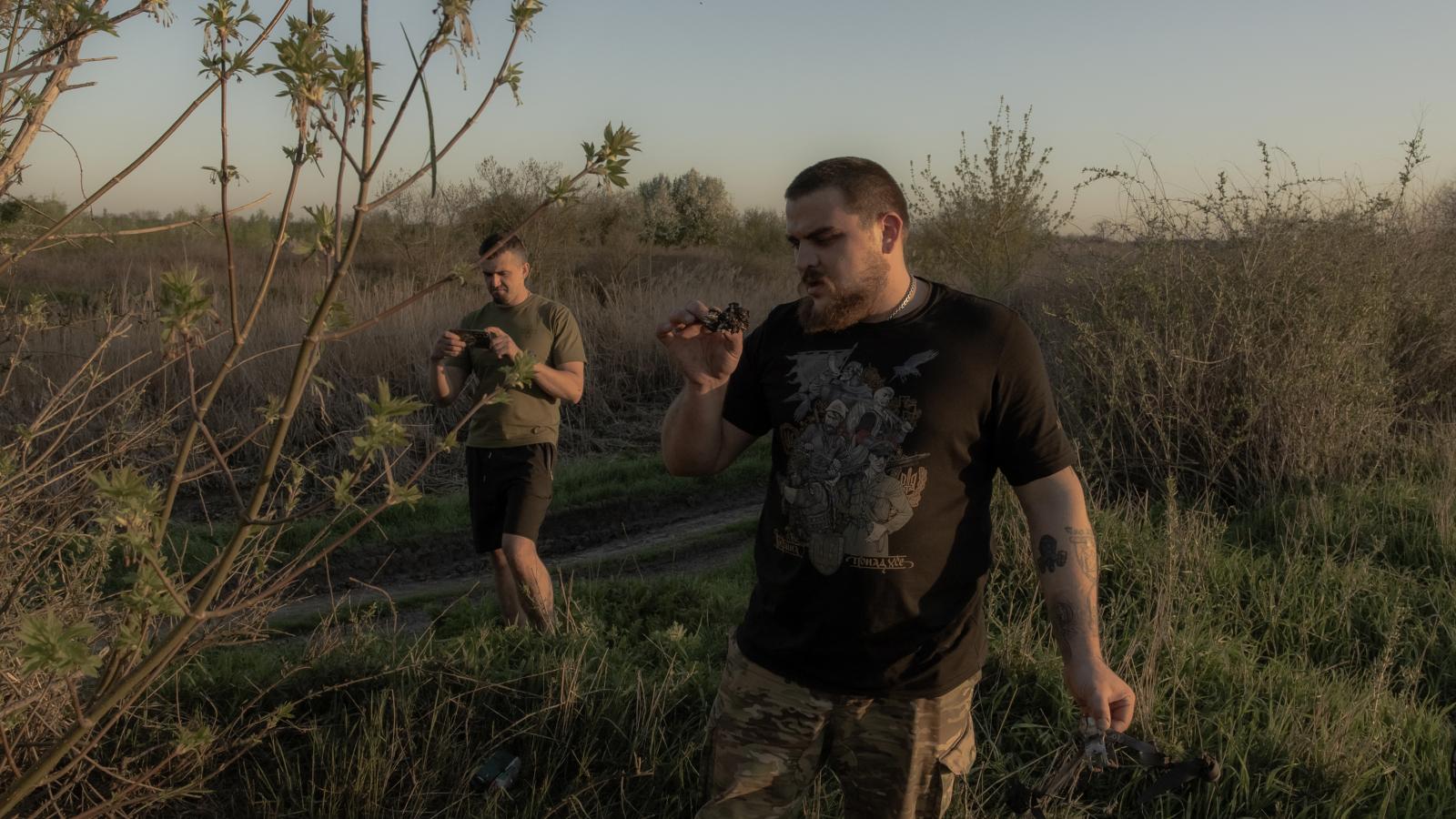 Ukrán katonák egy a tűzszünet idején becsapódott orosz drón darabjai vizsgálják