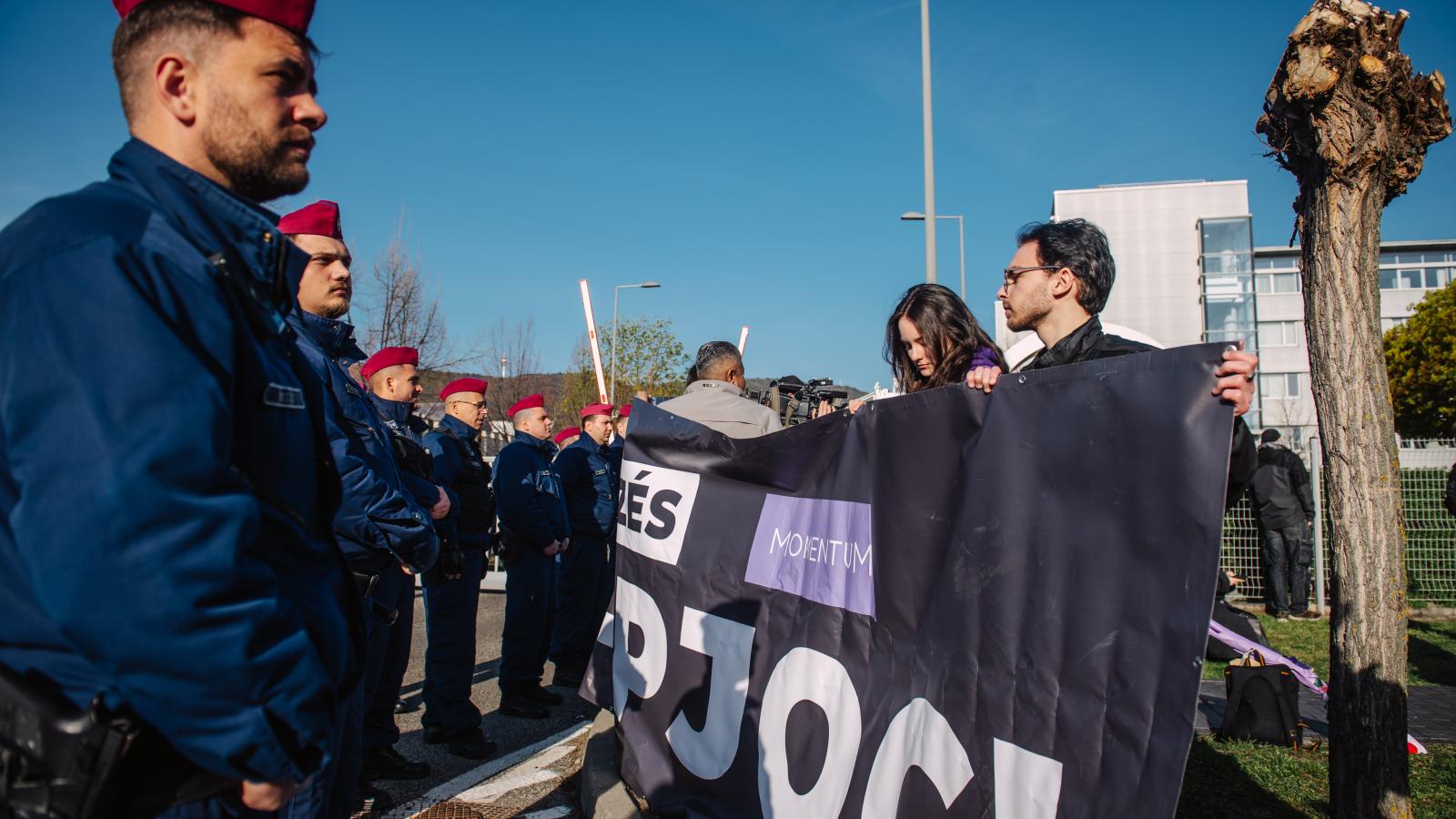 Rendőrsorfal és a Momentum aktivistái az MTVA épülete előtt április 11-én 