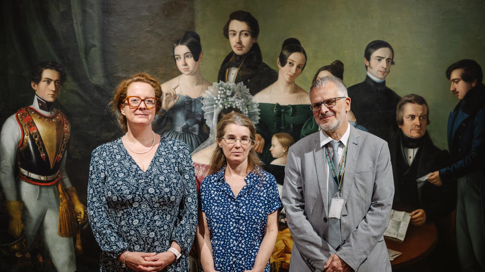 Molnárné Aczél Eszter, Radványi Orsolya és Farbaky Péter a Scherz Fülöp pozsonyi kereskedő családjáról készült festmény előtt