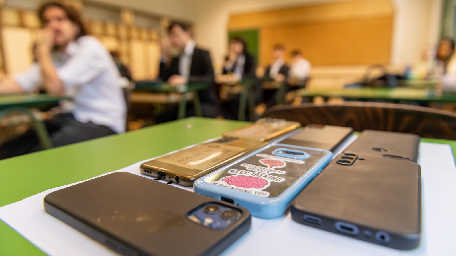 Az előtérben a telefonok, a háttérben a diákok