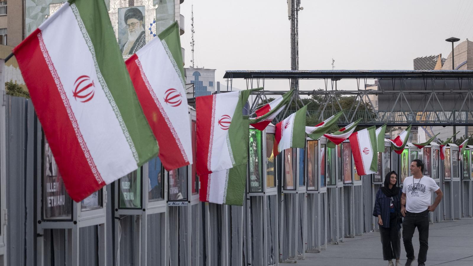 Egy iráni pár sétál az izraeli támadásokban elesett iráni civilek és az IRGC parancsnokainak emlékművei mellett Teherán belvárosában, 2025. június 23-án