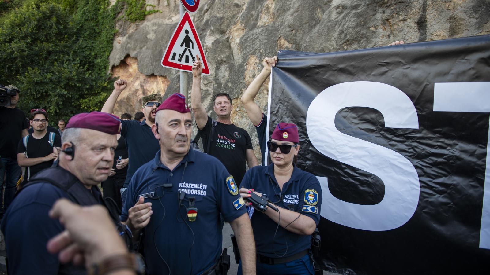 Ellentüntetők rendőrökkel körbevéve a Pride-on 2025. június 28-án