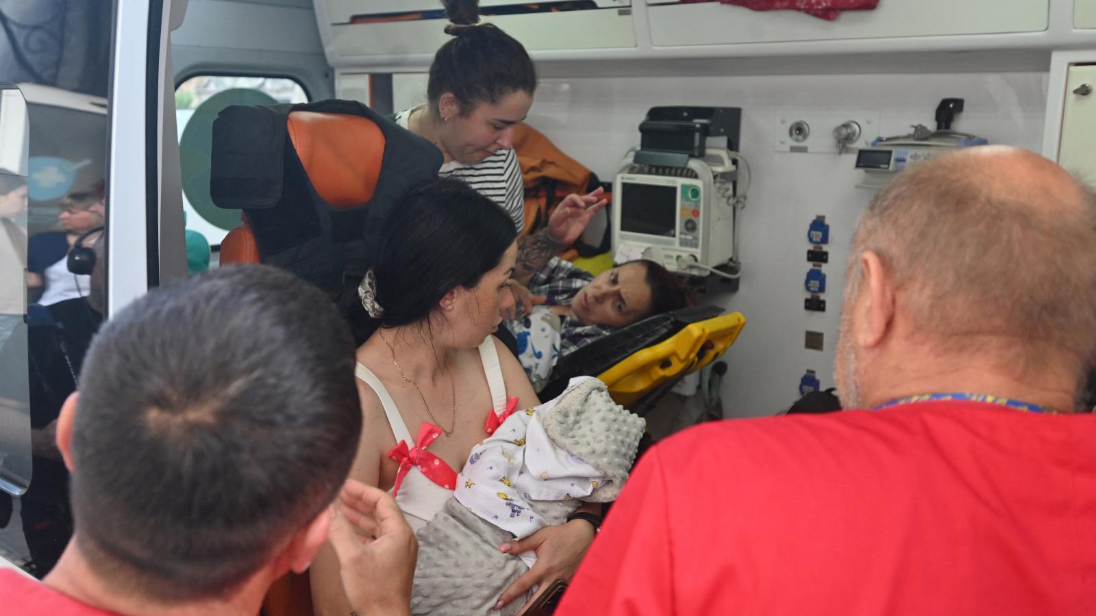 Az egészségügyi személyzet anyákat és újszülöttjeiket evakuál egy szülészeti kórházból, amely megsérült egy dróntámadás után Harkiv központjában, 2025. július 11-én